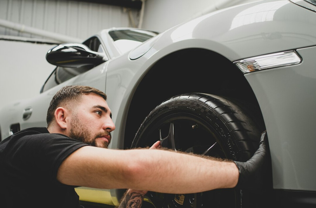 Technician inspecting a car in a garage
